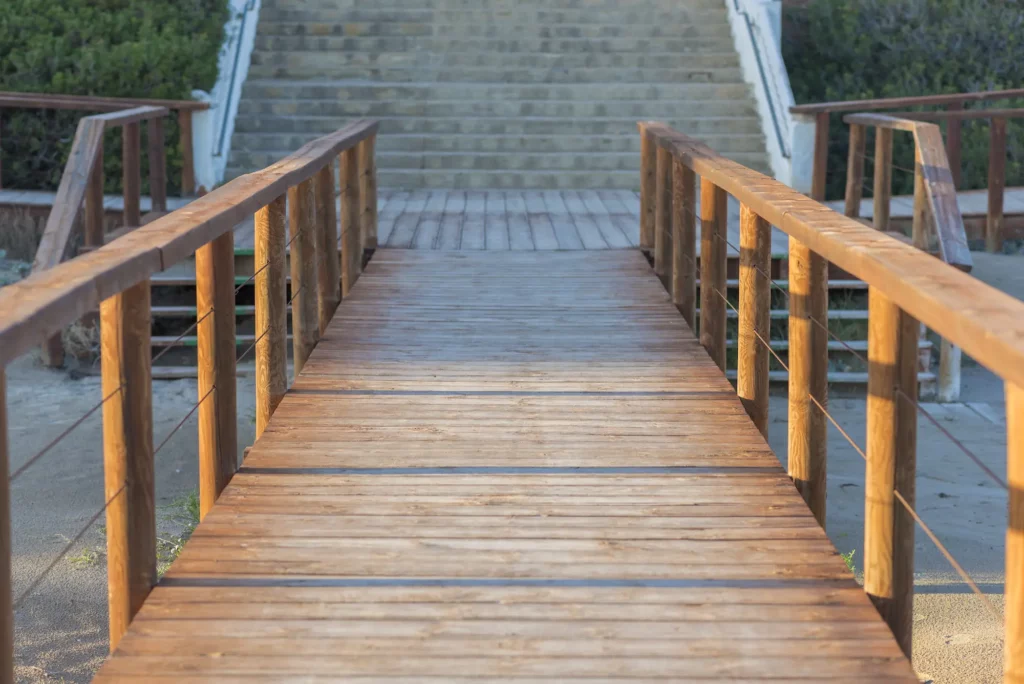 Wooden boardwalk leading to beach stairs daytime 2026 03 26 01 49 46 utc